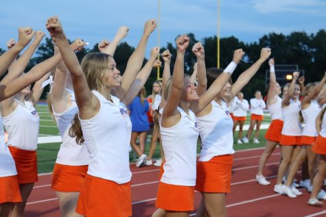 The varsity cheer squad pumps up the football teams at the blue and orange scrimmage game.