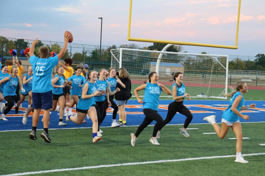 The Sophomore team runs out onto the football field before their game.