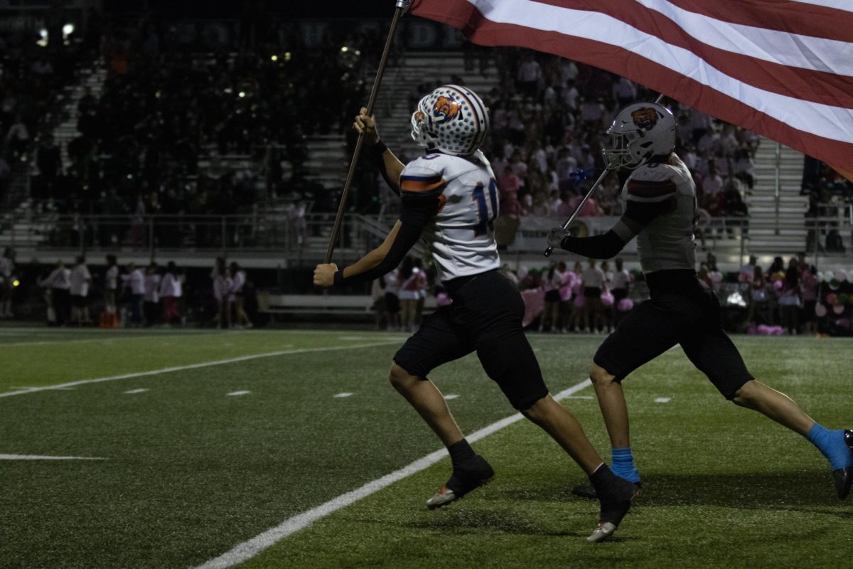 Getting hyped before the games oftentimes included carrying the flags through the inflatable football. Lucas Sapp ('26) flies the flag proudly next to Brody Wilmes ('26).